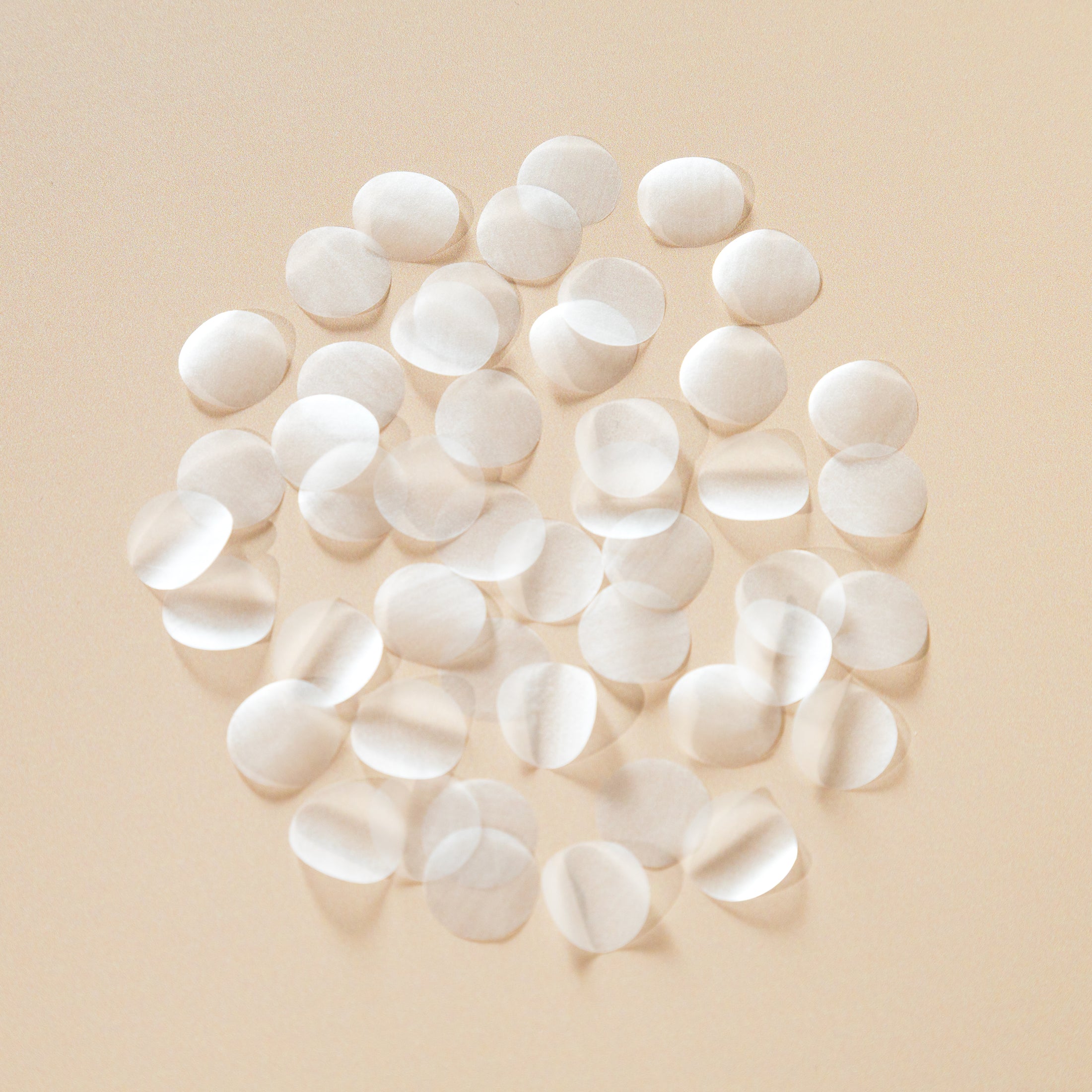 White circle biodegradable confetti pieces arranged on a beige background - The Confetti Farm
